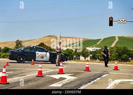 Kalifornien, Vereinigte Staaten von Amerika - 12. Juni 2024: Polizeibeamte kontrollieren den Verkehr an einer Kreuzung in Kalifornien, USA. Die Straßensperrung wird von Beamten der California Highway Patrol überwacht, wobei Verkehrskegel und Polizeifahrzeuge für die Sicherheit sorgen *** Polizeikräfte kontrollieren den Verkehr an einer Kreuzung in Kalifornien, USA. Die Straßensperrung wird durch offizielle der California Highway Patrol überwacht, wobei Verkehrshütchen und Polizeifahrzeuge für Sicherheit sorgen Stockfoto