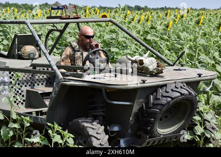 Ein ukrainischer Soldat aus dem Evakuierungsteam der 65. Separaten Mechanisierten Brigade sitzt im Evakuierungswagen bei Orichhiv. Ukrainische Verteidiger benutzen Strandbuggys, Geländefahrzeuge und Elektrofahrräder an der Front, da diese Fahrzeuge leiser und schwieriger zu sehen und zu hören sind. Dies gibt Soldaten an der Front eine bessere Chance, russischen Drohnen zu entgehen und zu überleben. Diese kleinen Fahrzeuge waren kein Ersatz für traditionelle Militärfahrzeuge. Sie verfügen nicht über die Feuerkraft und den Platz, um eine große Anzahl von Personen oder Fracht zu transportieren, und ihr Mangel an Rüstung macht alle an Bord verwundbar. Bu Stockfoto