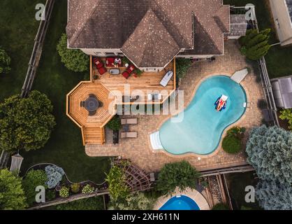 Aerial drone view of a house and backyard with pool in summer. Stock Photo