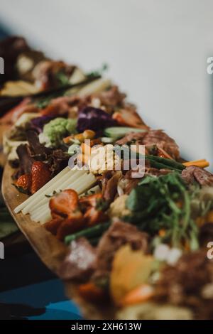 Close-up of a vibrant charcuterie board with assorted veggies & meats. Stockfoto