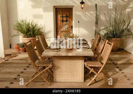 Rustic outdoor dining setup with wooden chairs and table Stockfoto