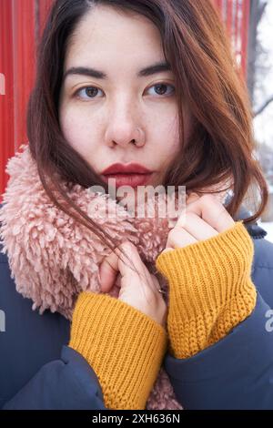 Porträt eines asiatischen Mädchens vor dem Hintergrund roter Stäbe Stockfoto