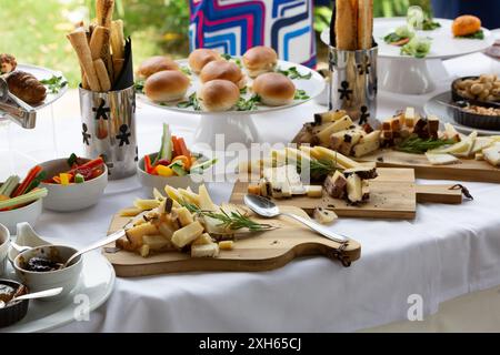 Auf einem Tisch bei einer Gartenparty im Freien werden köstliche Partygerichte serviert, die auf die Ankunft der Gäste warten Stockfoto