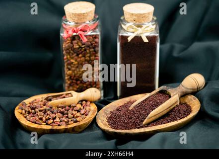 sizilianischer Sumach (Rhus coriaria), getrocknete Sumaksamen, ganz und in Gläsern gemahlen Stockfoto