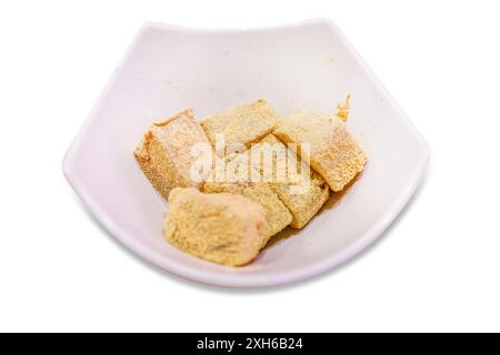 Gestanzte japanische Warabi-Mochi in weißer Schüssel auf weiß isoliert. Stockfoto