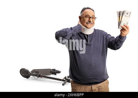 Reifer Mann mit einer Nackenverletzung, der Geld hält und vor einem Elektroroller steht, isoliert auf weißem Hintergrund Stockfoto