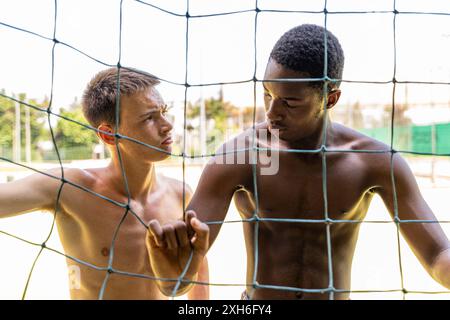 Porträt zweier junger multiethnischer Basketballspieler auf dem Spielfeld an einem sonnigen Sommertag Stockfoto