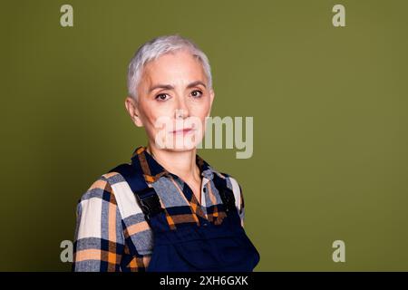 Foto der attraktiven Reifen Frau professionelle Mechaniker Look Kamera gekleidet blaue Arbeitskleidung insgesamt isoliert auf khakifarbenem Hintergrund Stockfoto