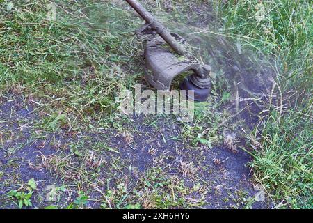 Eine Elektro- oder Benzinmaschine mit Griff zum Mähen von Gras auf einem Rasen Stockfoto