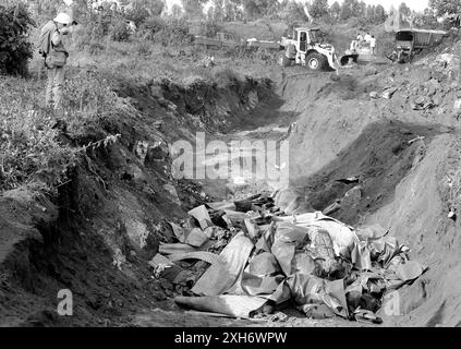 ZAIRE : Ein Pressefotograf / Fotoreporter fotografiert Leichen in einer Grube von Leichen die an der Choleraepidemie in der Nähe von Goma gestorben sind , Juli 1994 [automatisierte Übersetzung] Stockfoto