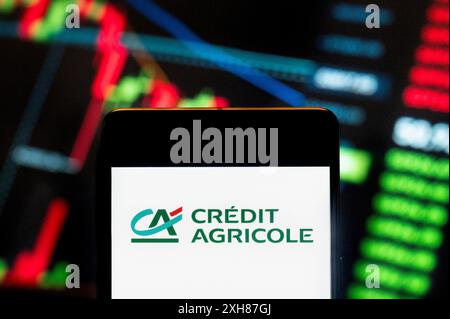 China. Juni 2024. In dieser Fotoabbildung wird das weltweit größte genossenschaftliche Finanzinstitut Credit Agricole (EPA: ACA) auf einem Smartphone mit einem wirtschaftlichen Börsenindex-Diagramm im Hintergrund dargestellt. (Foto von Budrul Chukrut/SOPA Images/SIPA USA) *** ausschließlich für redaktionelle Nachrichten *** Credit: SIPA USA/Alamy Live News Stockfoto