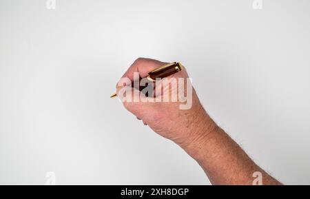 Kaukasische männliche Hand, die einen Kugelschreiber mit Holzgehäuse auf weißem Hintergrund hält Stockfoto