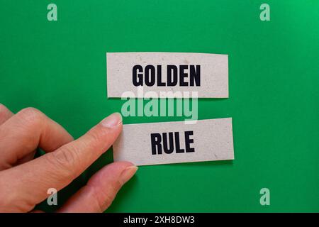 Goldene Regelbotschaft auf Papierstücken mit grünem Hintergrund. Konzeptionelles goldenes Regelsymbol. Kopierbereich. Stockfoto