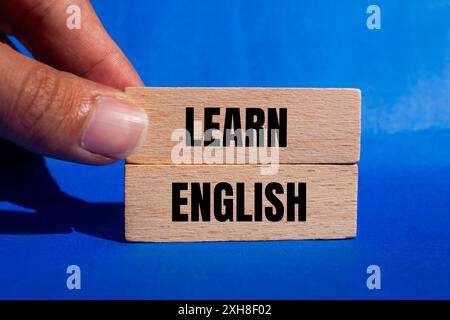 Lernen Sie englische Botschaft auf Holzblöcken mit blauem Hintergrund. Symbol für konzeptuelles Lernen englisch. Kopierbereich. Stockfoto