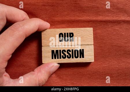 Unsere Botschaft auf Holzblöcken mit braunem Hintergrund. Konzeptionelles unser Missionssymbol. Kopierbereich. Stockfoto