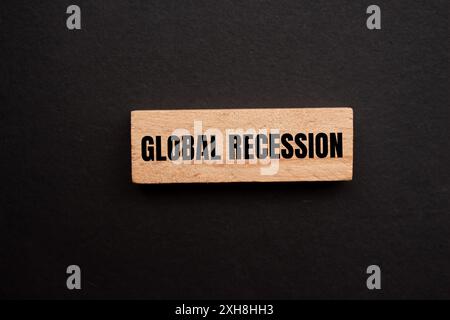 Globale Rezessionsbotschaft auf einem einzelnen Holzblock mit schwarzem Hintergrund geschrieben. Konzeptionelles globales Rezessionssymbol. Kopierbereich. Stockfoto