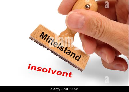 Mittelstand ein Holzstempel ist beschriftet mit dem Aufdruck Mittelstand und dem Abdruck insolvent *** Mittelstand Ein Holzstempel ist mit dem Aufdruck Mittelstand beschriftet Stockfoto