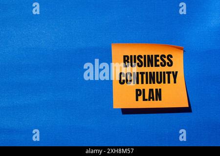Mitteilung zum Business Continuity Plan auf orangefarbenem Papier mit blauem Hintergrund. Symbol für den konzeptionellen Business Continuity Plan. Kopierbereich. Stockfoto