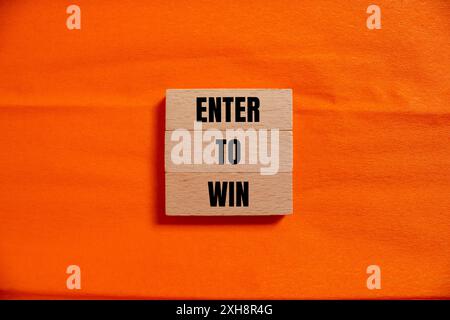 Geben Sie ein, um eine Nachricht zu gewinnen, die auf Holzblöcken mit orangefarbenem Hintergrund geschrieben ist. Symbol für die konzeptionelle Eingabe, um zu gewinnen. Kopierbereich. Stockfoto