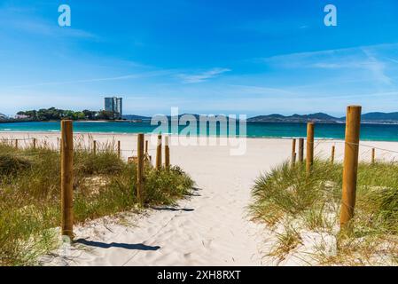 Umzäunter Pfad über feine Sanddünen am Strand O Vao, Gemeinde Corujo, mit Blick auf die Insel Toralla, in der Vigo-Mündung. Stockfoto