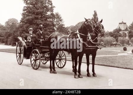 James Wilson (1835–1920), Landwirtschaftsminister von 1897 bis 1913, saß in einer Pferdekutsche mit einem unbekannten afroamerikanischen Fahrer. Wilson war Sekretär während drei Präsidentschaften und hält den Rekord als das am längsten dienende Mitglied des Kabinetts der Vereinigten Staaten. Vor seiner Amtszeit als Secretary war er Professor für Landwirtschaft am Iowa State Agricultural College (heute Iowa State University), wo er George Washington Carver beriet. (USA) Stockfoto