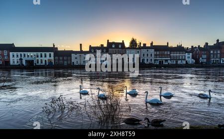 Bewdley bei Sonnenuntergang mit Schwänen auf dem überfluteten Fluss Stockfoto