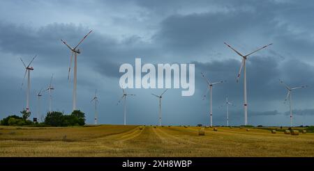 Sieversdorf, Deutschland. Juli 2024. Dunkle Sturmwolken ziehen mit einem Windpark im oder-Spree-Bezirk im Osten Brandenburgs über die Landschaft. Das Wochenende in Brandenburg beginnt mit Gewittern und starkem Regen unangenehm. Der Deutsche Wetterdienst (DWD) warnt vor lokalen Niederschlägen von bis zu 80 Litern pro Quadratmeter innerhalb weniger Stunden. Quelle: Patrick Pleul/dpa/Alamy Live News Stockfoto