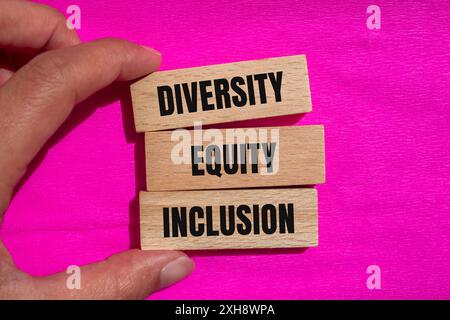 Wörter zur Einbeziehung von Diversity Equity Inclusion auf Holzblöcken mit rosa Hintergrund. DEI-Symbol für konzeptionelle Vielfalt der Gleichheit. Kopierbereich. Stockfoto