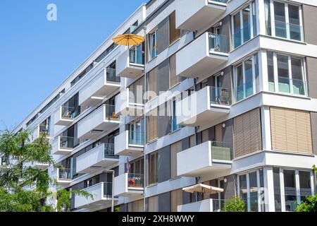 Modernes Mehrfamilienhaus mit gelbem Sonnenschirm in Berlin Stockfoto