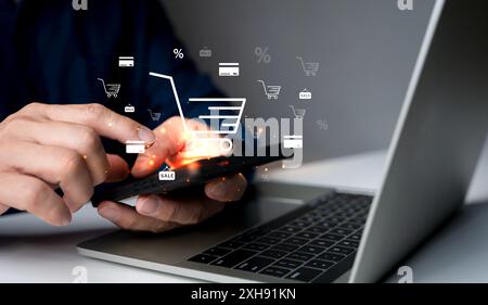 E-Commerce-Konzept für Unternehmen. Person verwendet Smartphone und Laptop mit Online-Einkaufswagen-Symbol auf dem virtuellen Bildschirm. Online-Kauf, E-Commerce-Shop, Onlin Stockfoto