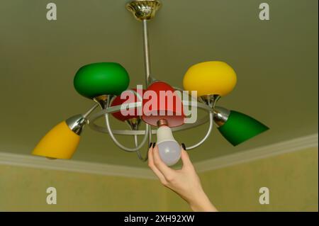 Austausch der LED-Lampe in der Lampe in der Wohnung Stockfoto