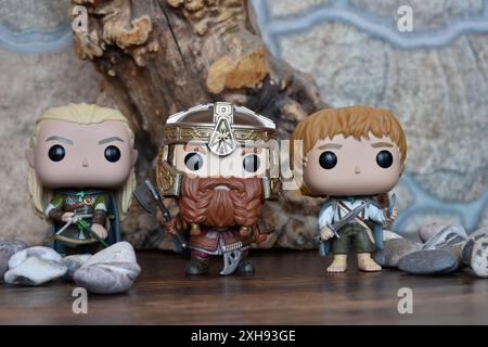 Funko Pop Actionfiguren von Elf Legolas, Zwerg Gimli und Hobbit Sam aus dem Fantasy-Film der Herr der Ringe. Krieger, Baum, Steine. Stockfoto