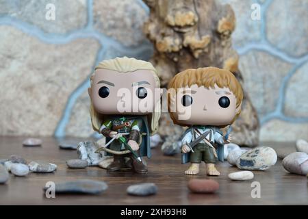 Funko Pop Actionfiguren von Elf Legolas und Hobbit Sam aus dem Fantasy-Film der Herr der Ringe. Krieger halten Schwert, Bogen und Pfeil, Baum, Steine. Stockfoto