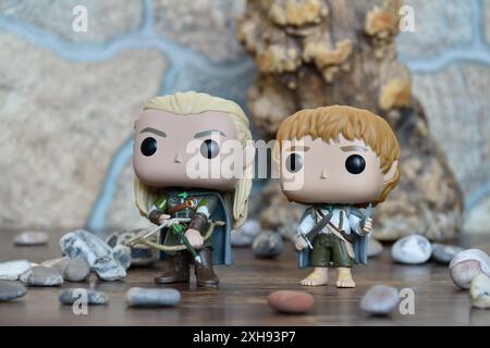 Funko Pop Actionfiguren von Elf Legolas und Hobbit Sam aus dem Fantasy-Film der Herr der Ringe. Krieger halten Schwert, Bogen und Pfeil, Baum, Steine. Stockfoto