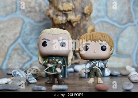 Funko Pop Actionfiguren von Elf Legolas und Hobbit Sam aus dem Fantasy-Film der Herr der Ringe. Krieger halten Schwert, Bogen und Pfeil, Baum, Steine. Stockfoto