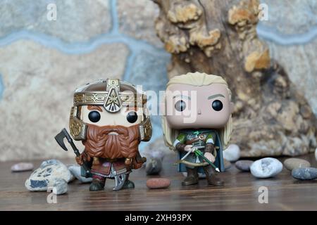 Funko Pop Actionfiguren von Gimli Zwerg und Elf Legolas aus dem Fantasy-Film der Herr der Ringe. Krieger in Rüstung, Baum, Steine. Stockfoto