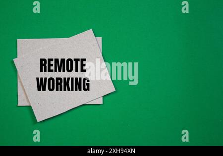 Meldung für die Fernbearbeitung auf einem Papierstück mit grünem Hintergrund. Konzeptionelles Symbol für Remote Working. Kopierbereich. Stockfoto