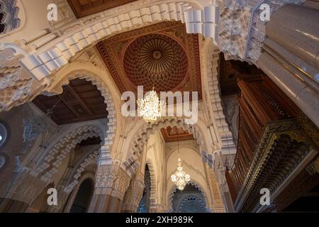 Hassan II Moschee, Marokko - 26. März 2024: Exquisite Decke und Kronleuchter in der Moschee. Sie zeigt marokkanische künstlerische Tradition und fortgeschrittene A Stockfoto