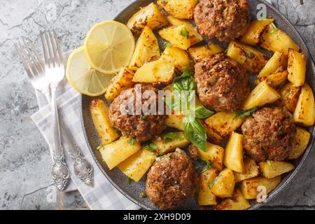 Bifteki One Pan griechische Burger und Kartoffeln aus der Nähe auf dem Teller auf dem Tisch. Horizontale Draufsicht von oben Stockfoto