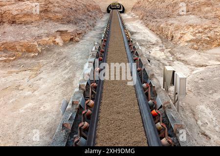 Mineralien, die auf einem langen Förderband in einer Kupfermine transportiert werden. Stockfoto