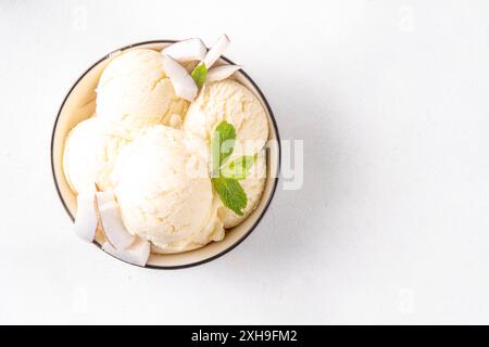 Veganes cremiges Kokos-Sorbet-Eis. Schüssel mit klassischem weißem Kokosgeschmack, vegetarisches Eis aus Kokosmilch, cremig gefrorener Sommer Stockfoto