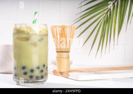 Grüner Matcha boba Sprudeltee mit Tapioka-Perle. Trendiges asiatisches kaltes Eisgetränk mit dunklen Tapioka-Bällchen und Schlagsahne ohne Milchprodukte, Kopierraum Stockfoto