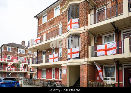 Bermondsey, London, 12. Juli 2024. Das Kirby Estate in Bermondsey, bekannt für seine farbenfrohen Flaggendekorationen für Fußballspiele Englands, ist wieder einmal mit mehreren hundert Flaggen auf dem patriotischen Anwesen, sowie dem kürzlich enthüllten Wandgemälde von Eberechi Eze und anderen farbenfrohen Wandgemälden in den Rillen, vor dem Finale der Fußball-Europameisterschaft England gegen Spanien am Sonntag. Quelle: Imageplotter/Alamy Live News Stockfoto