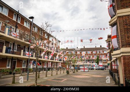 Bermondsey, London, 12. Juli 2024. Das Kirby Estate in Bermondsey, bekannt für seine farbenfrohen Flaggendekorationen für Fußballspiele Englands, ist wieder einmal mit mehreren hundert Flaggen auf dem patriotischen Anwesen, sowie dem kürzlich enthüllten Wandgemälde von Eberechi Eze und anderen farbenfrohen Wandgemälden in den Rillen, vor dem Finale der Fußball-Europameisterschaft England gegen Spanien am Sonntag. Quelle: Imageplotter/Alamy Live News Stockfoto