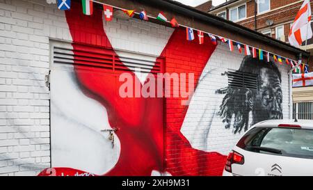 Bermondsey, London, 12. Juli 2024. Das Kirby Estate in Bermondsey, bekannt für seine farbenfrohen Flaggendekorationen für Fußballspiele Englands, ist wieder einmal mit mehreren hundert Flaggen auf dem patriotischen Anwesen, sowie dem kürzlich enthüllten Wandgemälde von Eberechi Eze und anderen farbenfrohen Wandgemälden in den Rillen, vor dem Finale der Fußball-Europameisterschaft England gegen Spanien am Sonntag. Quelle: Imageplotter/Alamy Live News Stockfoto