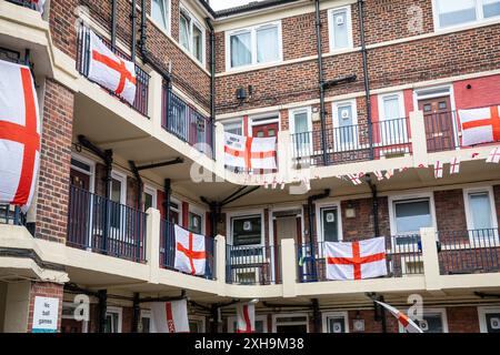 Bermondsey, London, 12. Juli 2024. Das Kirby Estate in Bermondsey, bekannt für seine farbenfrohen Flaggendekorationen für Fußballspiele Englands, ist wieder einmal mit mehreren hundert Flaggen auf dem patriotischen Anwesen, sowie dem kürzlich enthüllten Wandgemälde von Eberechi Eze und anderen farbenfrohen Wandgemälden in den Rillen, vor dem Finale der Fußball-Europameisterschaft England gegen Spanien am Sonntag. Quelle: Imageplotter/Alamy Live News Stockfoto