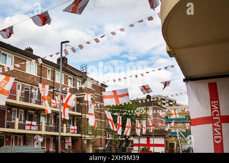 Bermondsey, London, 12. Juli 2024. Das Kirby Estate in Bermondsey, bekannt für seine farbenfrohen Flaggendekorationen für Fußballspiele Englands, ist wieder einmal mit mehreren hundert Flaggen auf dem patriotischen Anwesen, sowie dem kürzlich enthüllten Wandgemälde von Eberechi Eze und anderen farbenfrohen Wandgemälden in den Rillen, vor dem Finale der Fußball-Europameisterschaft England gegen Spanien am Sonntag. Quelle: Imageplotter/Alamy Live News Stockfoto