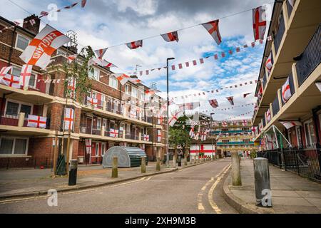 Bermondsey, London, 12. Juli 2024. Das Kirby Estate in Bermondsey, bekannt für seine farbenfrohen Flaggendekorationen für Fußballspiele Englands, ist wieder einmal mit mehreren hundert Flaggen auf dem patriotischen Anwesen, sowie dem kürzlich enthüllten Wandgemälde von Eberechi Eze und anderen farbenfrohen Wandgemälden in den Rillen, vor dem Finale der Fußball-Europameisterschaft England gegen Spanien am Sonntag. Quelle: Imageplotter/Alamy Live News Stockfoto