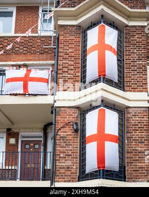 Bermondsey, London, 12. Juli 2024. Das Kirby Estate in Bermondsey, bekannt für seine farbenfrohen Flaggendekorationen für Fußballspiele Englands, ist wieder einmal mit mehreren hundert Flaggen auf dem patriotischen Anwesen, sowie dem kürzlich enthüllten Wandgemälde von Eberechi Eze und anderen farbenfrohen Wandgemälden in den Rillen, vor dem Finale der Fußball-Europameisterschaft England gegen Spanien am Sonntag. Quelle: Imageplotter/Alamy Live News Stockfoto