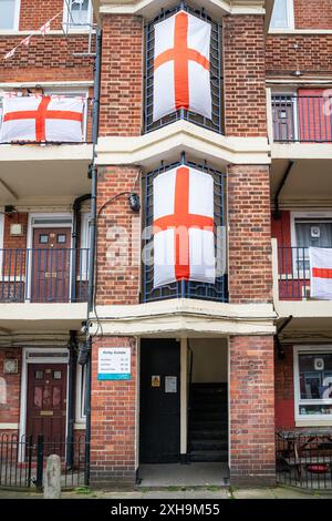 Bermondsey, London, 12. Juli 2024. Das Kirby Estate in Bermondsey, bekannt für seine farbenfrohen Flaggendekorationen für Fußballspiele Englands, ist wieder einmal mit mehreren hundert Flaggen auf dem patriotischen Anwesen, sowie dem kürzlich enthüllten Wandgemälde von Eberechi Eze und anderen farbenfrohen Wandgemälden in den Rillen, vor dem Finale der Fußball-Europameisterschaft England gegen Spanien am Sonntag. Quelle: Imageplotter/Alamy Live News Stockfoto